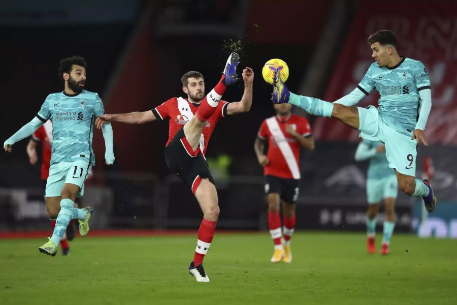 Southamptons Jack Stephens (m.) im Duell mit Roberto Firmino (r.) vom FC Liverpool.