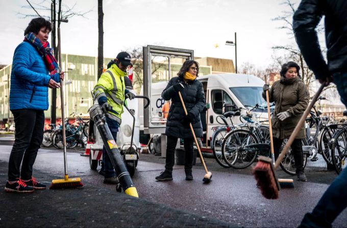 Frewillige helfen am Montagmorgen bei den Aufräumarbeiten rund um den Hauptbahnhof in Eindhoven. freiwillige aufräumen Eindhoven krawalle