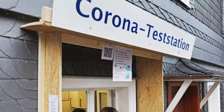 Ein Apotheker nimmt von einer Frau einen Abstrich an einer Corona-Teststation in Wipperfürth. Foto: Oliver Berg/dpa