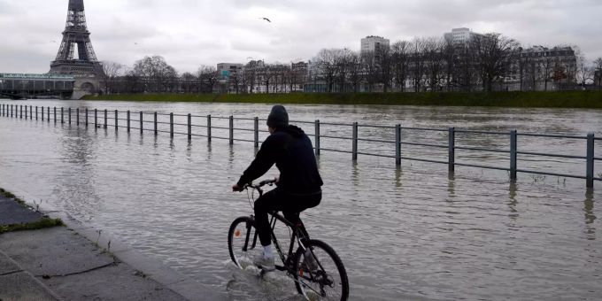 Ein Fahrradfahrer fährt durch Wasser am übergetretenen Ufer der Seine. Wegen Hochwassers hat die französische Metropole mehrere Abschnitte am Ufer gesperrt. Der Pegelstand des Flusses stieg auf über vier Meter an. Hochwasser Seine in Paris
