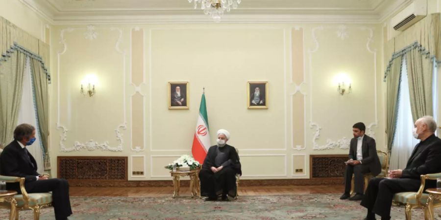 HANDOUT - Hassan Ruhani (2.v.l), Präsident des Iran, nimmt an einem gemeinsamen Treffen mit Rafael Grossi (l), Vorsitzender der Internationalen Atomenergiebehörde IAEA, teil. Foto: -/Iranian Presidency /dpa - ACHTUNG: Nur zur redaktionellen Verwendung und nur mit vollständiger Nennung des vorstehenden Credits