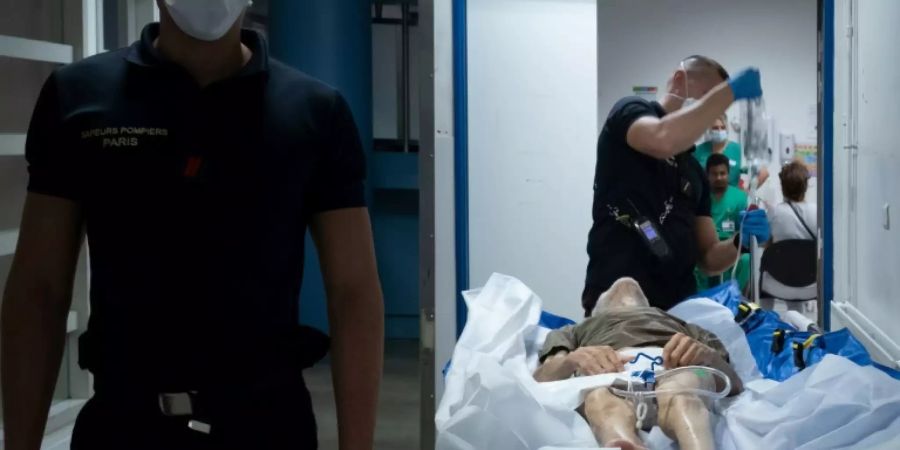 Rettungskräfte mit Corona-Patient in Saint-Denis