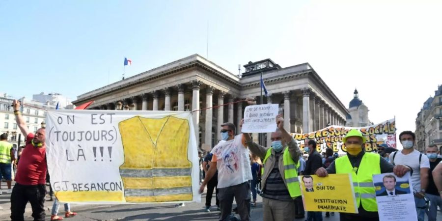 «Gelbwesten» in Paris mit Transparent «Wir sind noch da»