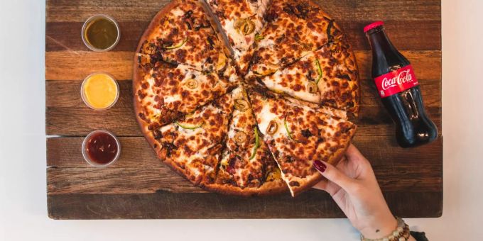 Fertiggerichte sind meist ungesund. Pizzastücke und Coca Cola