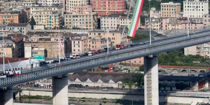 03.08.2020, Italien, Genua: Eine italienische Flagge weht im Rahmen der Einweihung der Brücke San Giorgio über der Brücke. Knapp zwei Jahre nach dem tödlichen Einsturz der Morandi-Autobahnbrücke hat Italiens Staatsspitze den fertigen Neubau eingeweiht. Foto: Antonio Calanni/AP/dpa +++ dpa-Bildfunk +++ Neue Autobahnbrücke in Genua wird feierlich eingeweiht