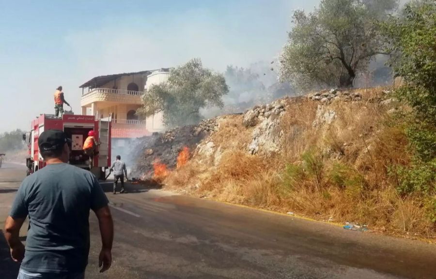 Die Feuerwehr und Helfer versuchen die Brände unter Kontrolle zu bringen.