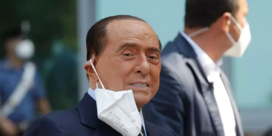 ARCHIV - Silvio Berlusconi, ehemaliger Ministerpräsident von Italien, nimmt seinen Mund-Nasen-Schutz ab, nachdem er das Krankenhaus San Raffaele verlassen hat. Berlusconi war ins Krankenhaus eingeliefert worden, um seine Corona-Infektion zu überwachen, nachdem er positiv auf Covid-19 getestet worden war. Foto: Luca Bruno/AP/dpa