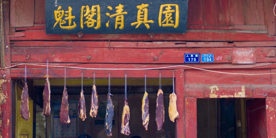 Fleisch hängt draussen in einer kleinen muslimischen Fleischerei in lijiang, china.