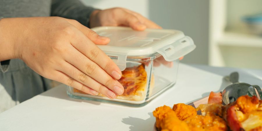Frauenhände halten Glasbox mit Essen