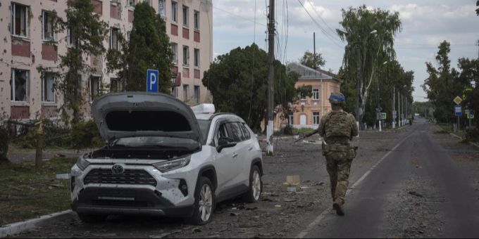 Ein ukrainischer Soldat neben einem zerstörten Auto in der russischen Region Kursk. kursk