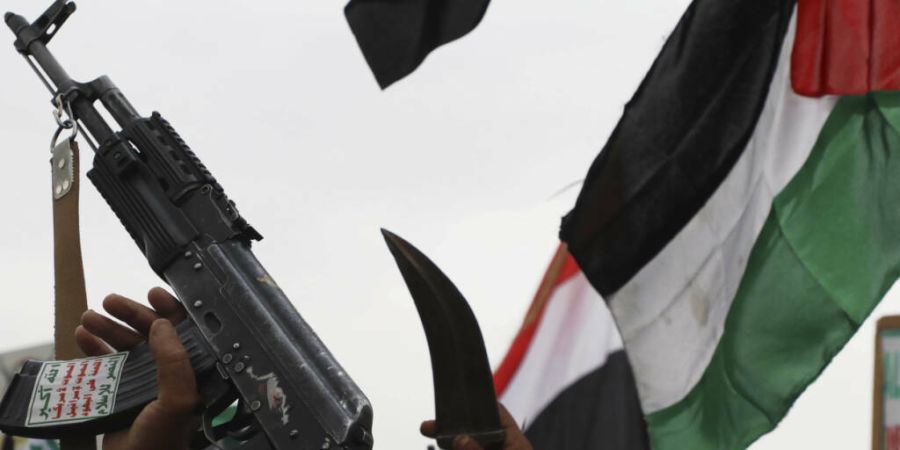 ARCHIV - Houthi-Anhänger rufen während einer wöchentlichen Anti-US- und Anti-Israel-Kundgebung Slogans und hissen eine palästinensische Flagge. Foto: Osamah Abdulrahman/AP/dpa