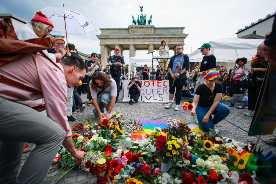 Vor dem Brandenburger Tor, unweit der Stelle, an der ein Fahrzeug in eine Menschenmenge am Rande der Christopher-Street-Day-Parade (CSD) in Berlin gerast war, trauern Menschen.