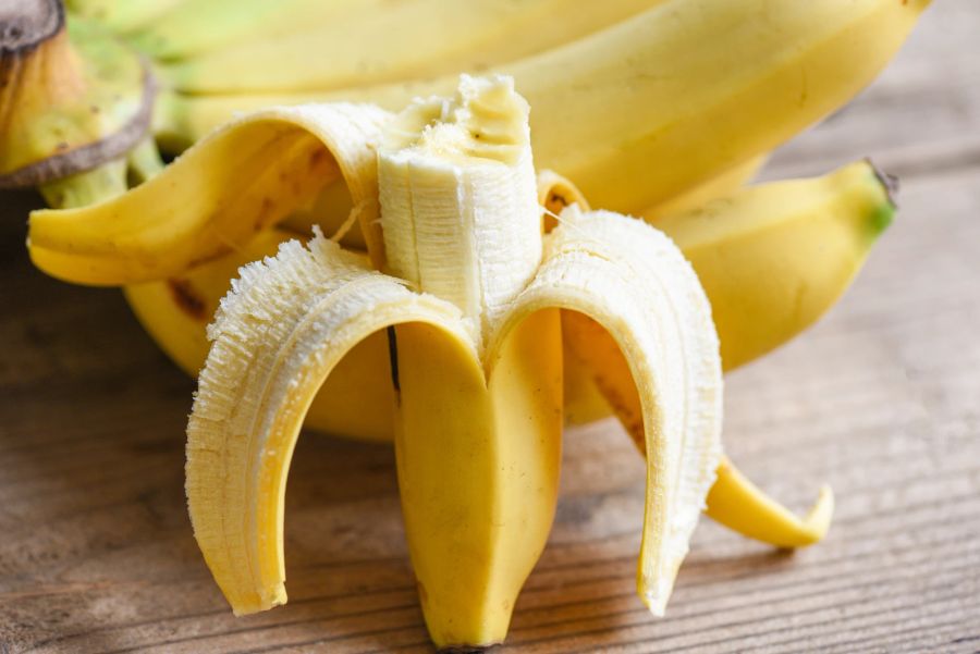 Bananen mit Schale auf Holzuntergrund