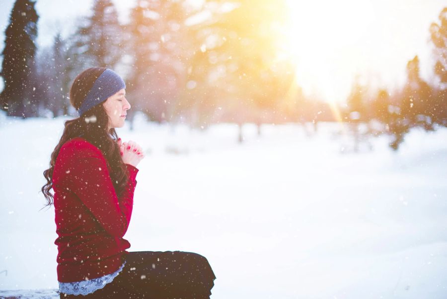 Frau meditiert im Schnee