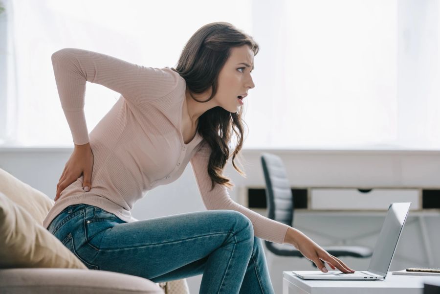 Frau auf Sofa mit Schmerzen