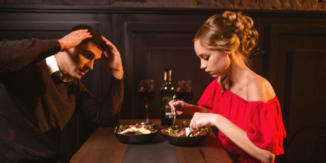 frau und mann beim date, mann verzweifelt, frau isst