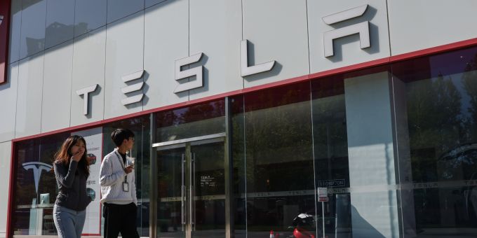 Zwei Leute spazieren an einem Tesla-Showroo vorbei. (Symbolbild) tesla