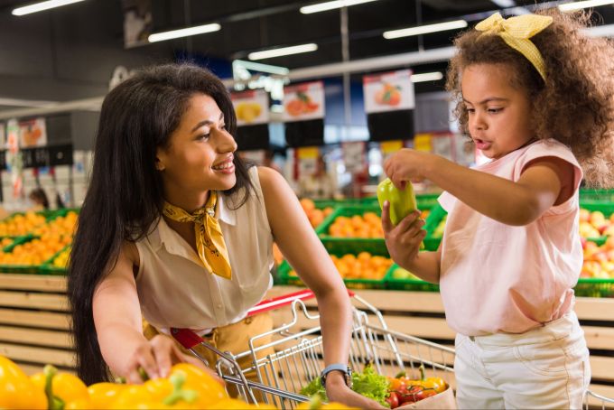 Ob beim Einkaufen oder in der Küche: Wichtig ist, Kinder in Alltagsaufgaben einzubinden, damit sie ihr erlerntes Wissen testen können. Mutter und Tochter beim Einkaufen