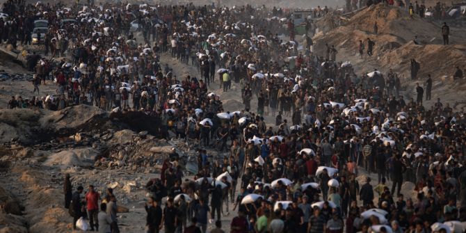 Displaced Palestinians carry bags of flour along Rashid Street in western Gaza City.