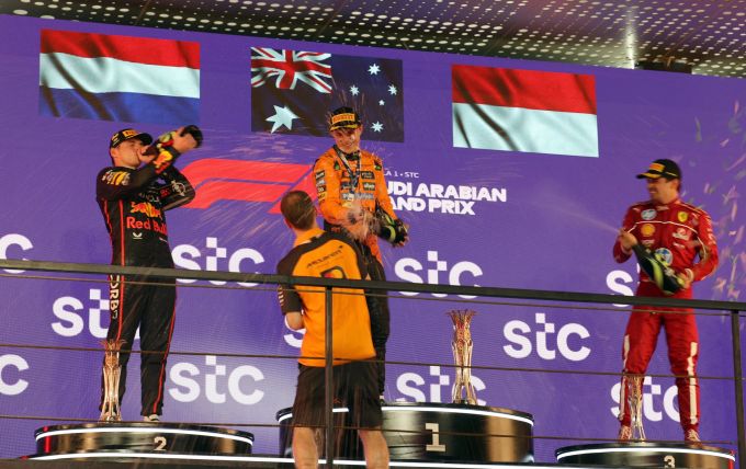Während Oscar Piastri und Charles Leclerc feiern, trinkt Max Verstappen aus der Champagner-Flasche. Formel 1