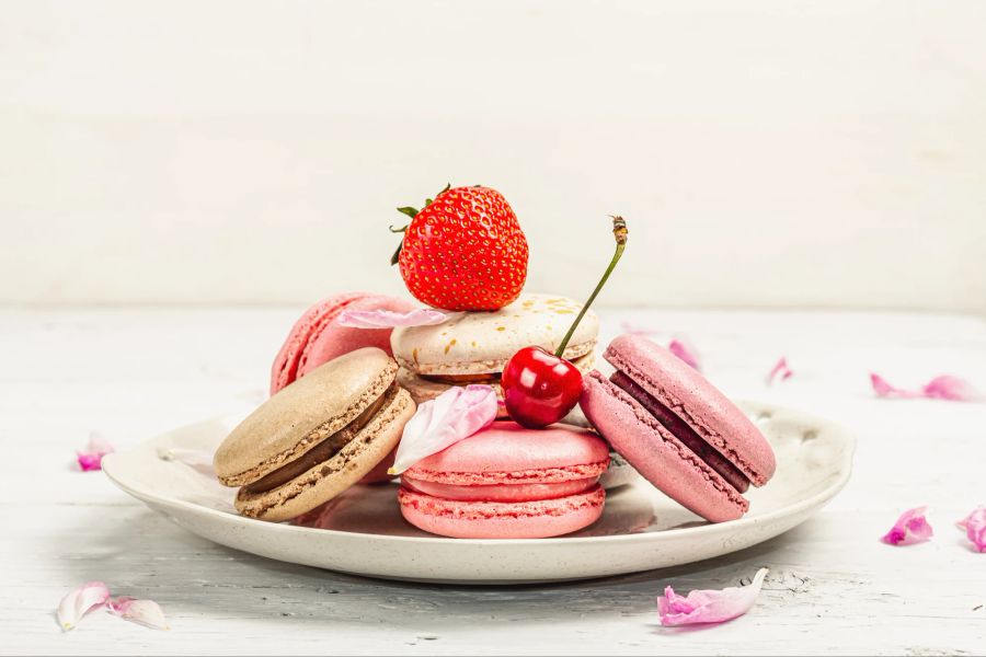 Macarons mit Erdbeeren, Kirschen und Blüten.