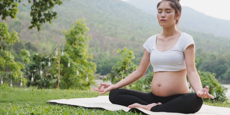 Schwangere praktiziert Yoga.