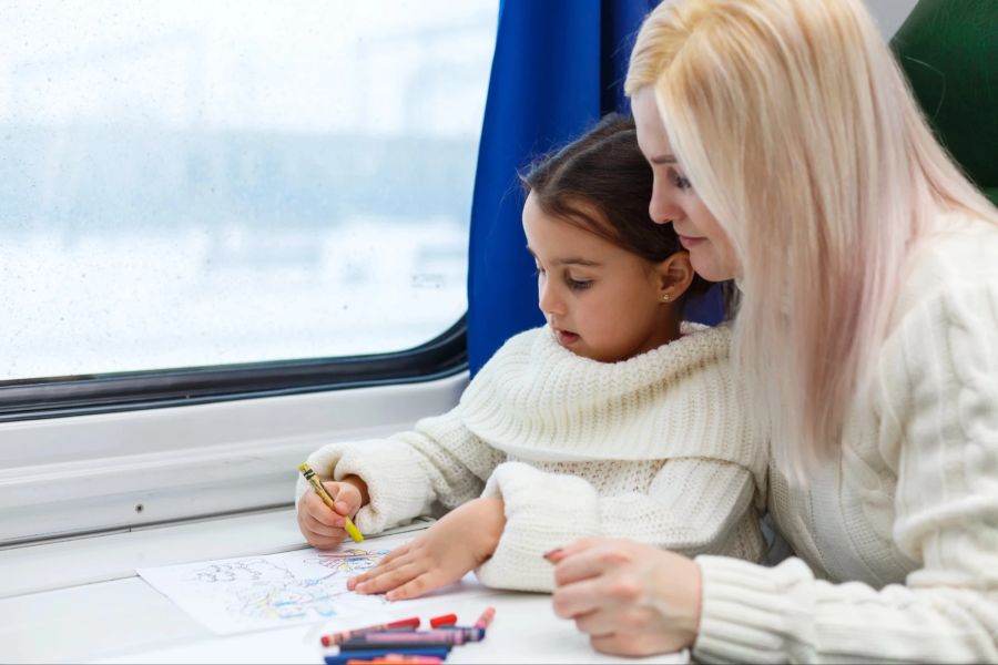 Mutter und Tochter malen im Zug.