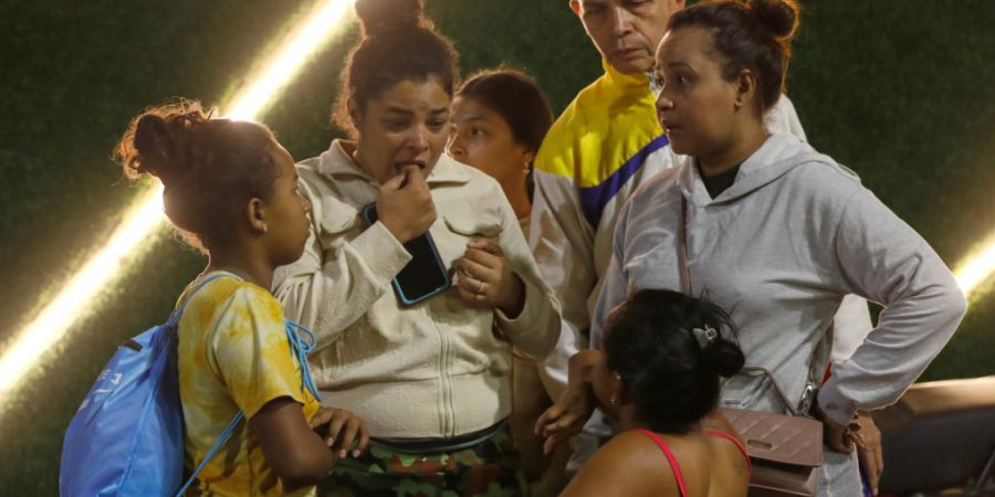 Anwohner aus einem Gebäude, das evakuiert wurde, stehen in der Nähe des Präsidentenpalastes Miraflores, nachdem Explosionen und tieffliegende Flugzeuge in Caracas, Venezuela, am Sams...