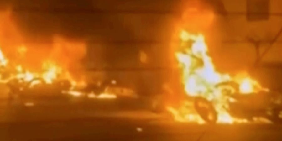 HANDOUT - Dieses Videostandbild aus dem iranischen Staatsfernsehen zeigt brennende Fahrzeuge während nächtlicher Massenproteste. Foto: Uncredited/Iran state TV/AP/dpa - ACHTUNG: Nur z...