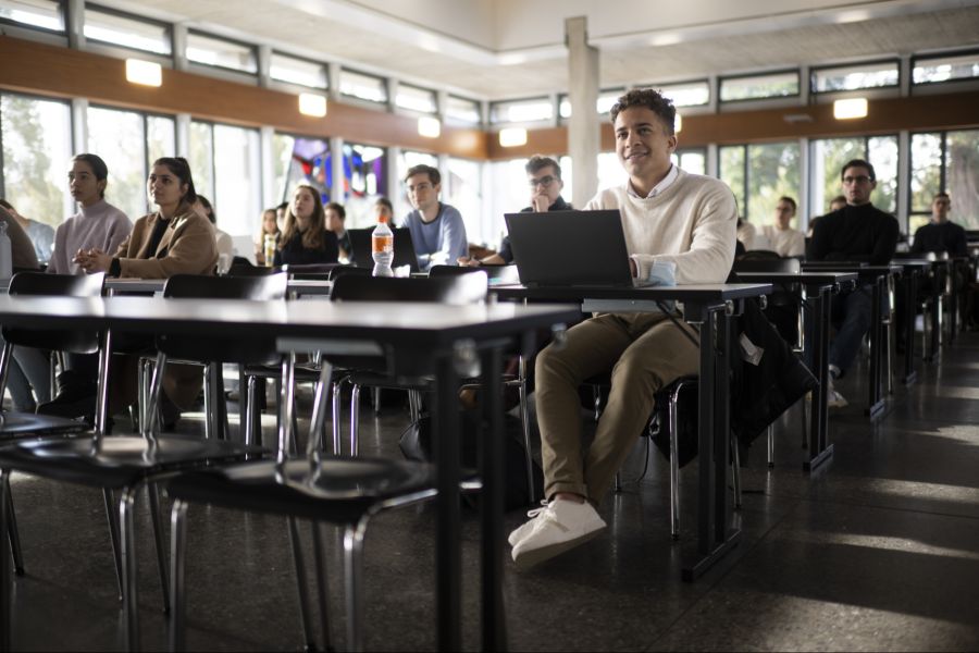 Studierende sitzen im Hörsaal vor ihren Laptops.