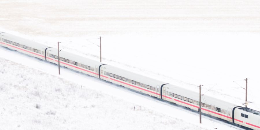 ARCHIV - Ein ICE der Deutschen Bahn in einer Winterlandschaft. Foto: Julian Stratenschulte/dpa/Archivbild