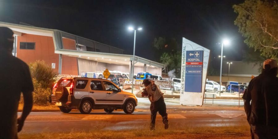 Menschen versammeln sich vor dem Krankenhaus in Alice Springs, wo ein Mann, der verdächtigt wird, ein fünfjähriges Mädchen getötet zu haben, von der Polizei bewacht wird. Foto: Rhe...