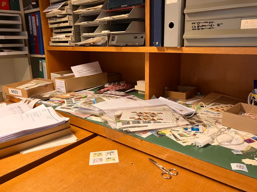 Lose Marken und kleine Couverts warten darauf, gezählt, geprüft und für den Verkauf vorbereitet zu werden.