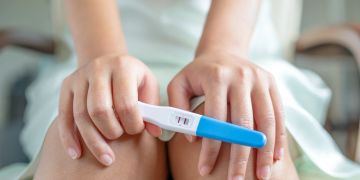 Frau hält positiven Schwangerschaftstest