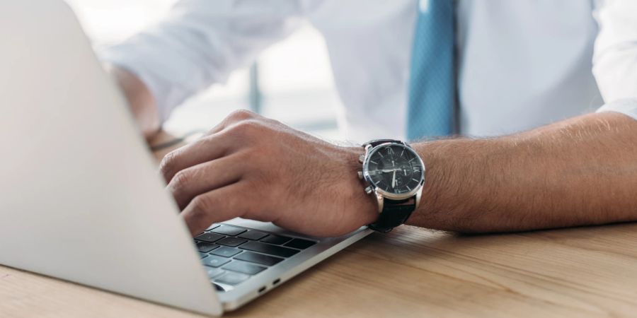 mann mit armbanduhr laptop