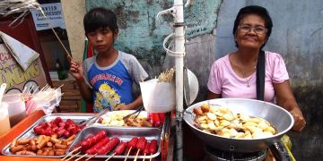 Frau Kind Straßenstand Philippinien Essen