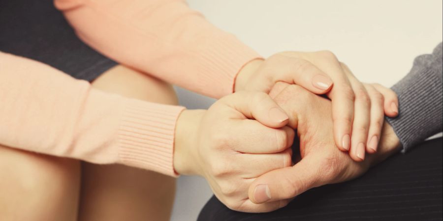 Frau hält tröstend Hand von Mann