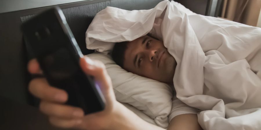 Mann im Bett, Smartphone