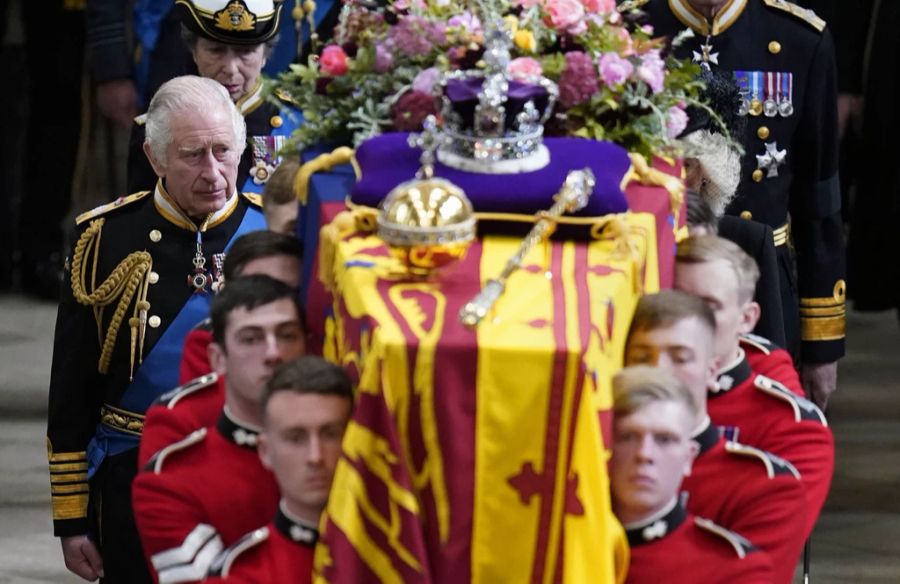 Die acht Männer tragen den Sarg aus der Westminster Abbey. King Charles und Prinzessin Anne folgen.