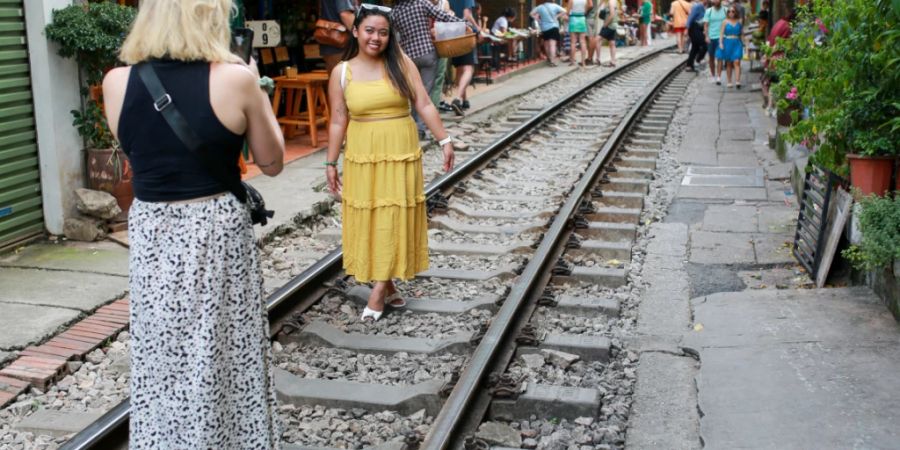 ARCHIV - Touristinnen machen Fotos für Instagram auf den Bahngleisen der berühmten «Train Street». Foto: Chris Humphrey/dpa