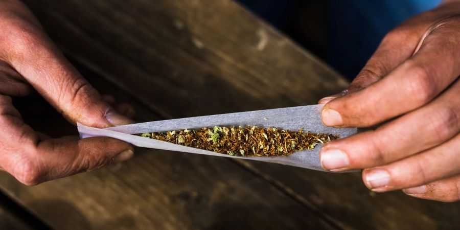 Ein Mann rollt einen Joint aus einer Mischung aus Tabak und Cannabis.