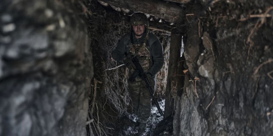 Ein ukrainischer Soldat steht in einem Graben an der Frontlinie einer Kleinstadt. Foto: Libkos/AP