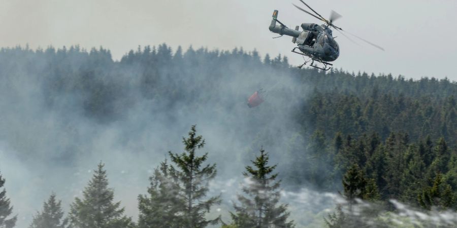 Die Feuerwehr versucht mit einem Hubschrauber einen Moorbrand im deutsch-belgischen Grenzgebiet bei Aachen zu löschen.