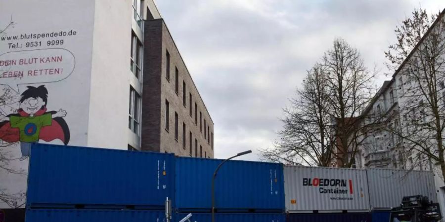 Ein Containerwand zur Minderung einer möglichen Druckwelle wird im Klinikviertel vor dem Institut für Transfusionsmedizin des Klinikums Dortmund errichtet. Foto: Bernd Thissen/dpa