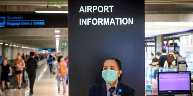 Eine Flughafenanstellte mit Schutzmaske in Bangkok. Schutzmaske
