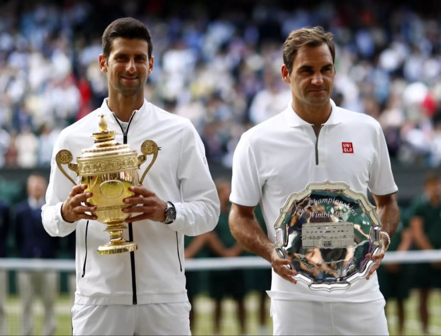 Novak Djokovic (l.) strahlt nach seinem Wimbledon-Triumph neben Roger Federer (r.).