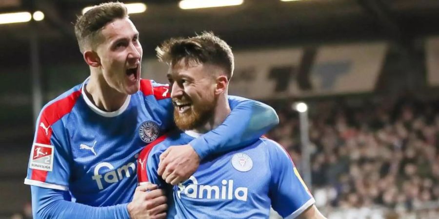 Holstein Kiels Salih Özcan (r) und Phil Neumann feiern Özcans Tor zum 1:0 gegen den FC St. Pauli. Foto: Christian Charisius/dpa