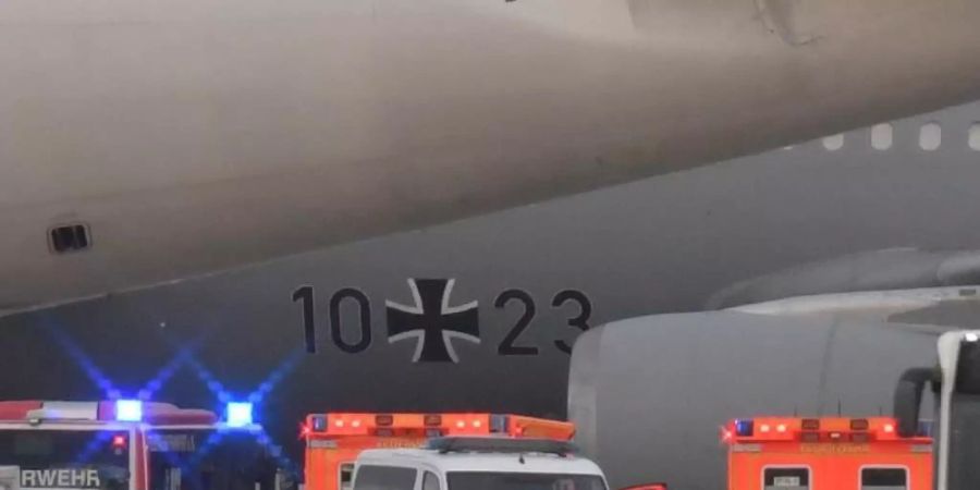 Rettungskräfte und Polizisten stehen neben dem Flugzeug bereit. Foto: Boris Roessler/dpa