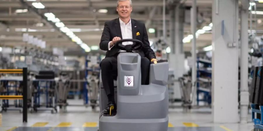 Hartmut Jenner, Vorsitzender des Vorstands der Alfred Kärcher SE &amp; Co. KG, in einer Werkshalle auf einer Scheuersaugmaschine. Foto: Marijan Murat/dpa