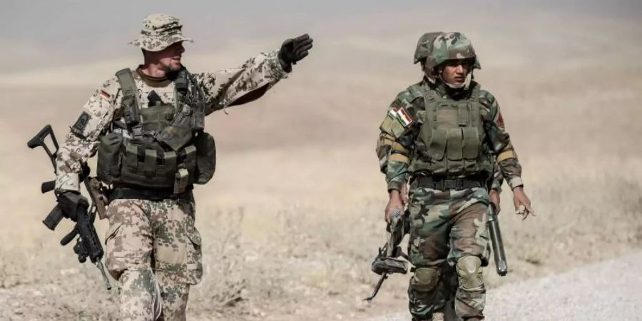 Ein Bundeswehrsoldat und Kämpfer der kurdischen Peshmerga während der Ausbildung nahe Erbil im Norden des Irak. Foto: Michael Kappeler/dpa